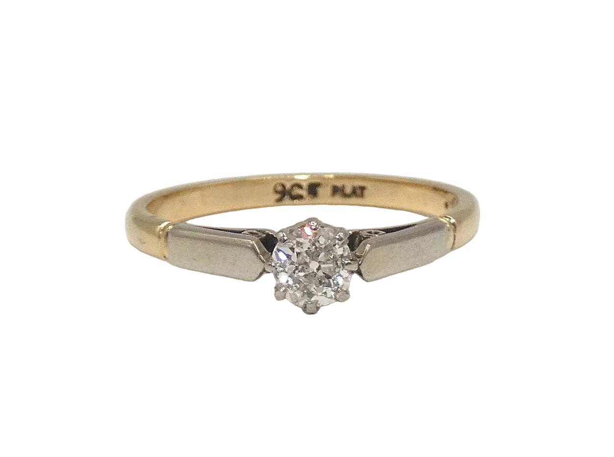 Two-tone gold ring with a diamond on a white background