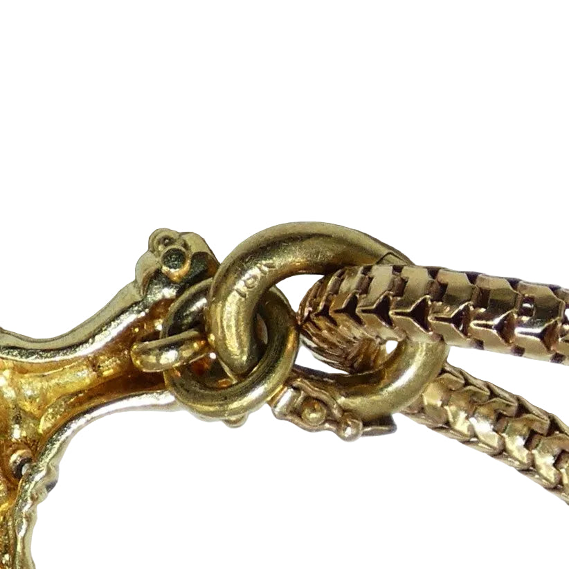 Close-up of a gold chain with intricate design on a white background