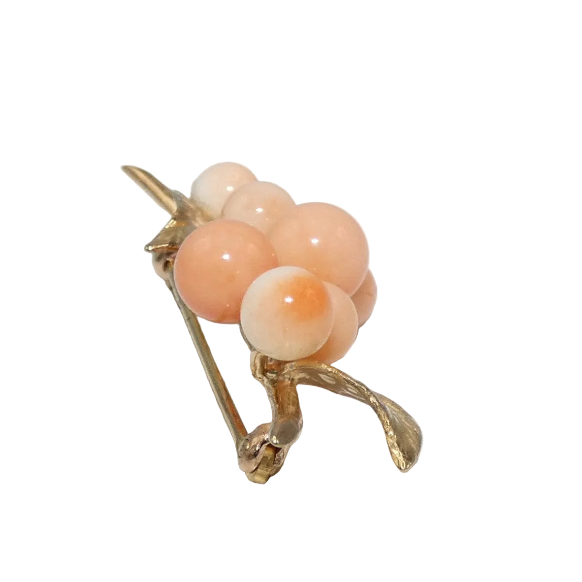 A vintage gold brooch shaped like a cluster of peach-colored corals.