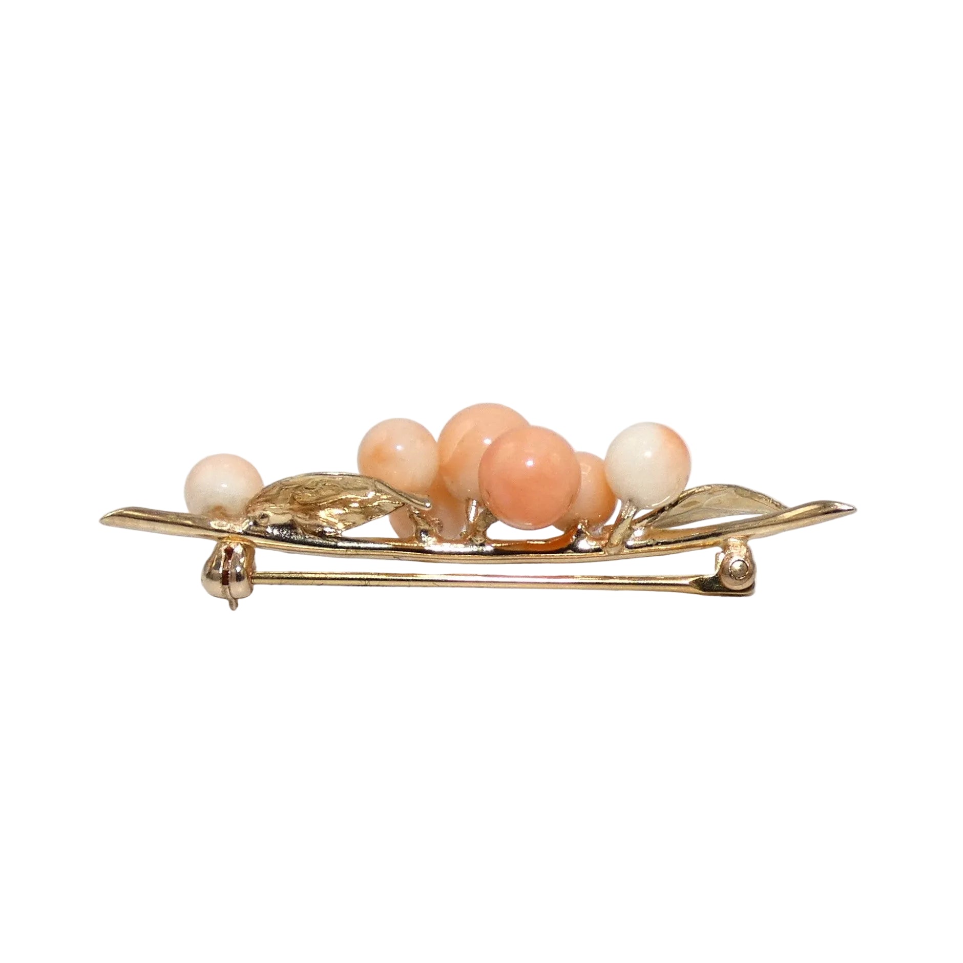 A vintage gold brooch shaped like a cluster of peach-colored corals.