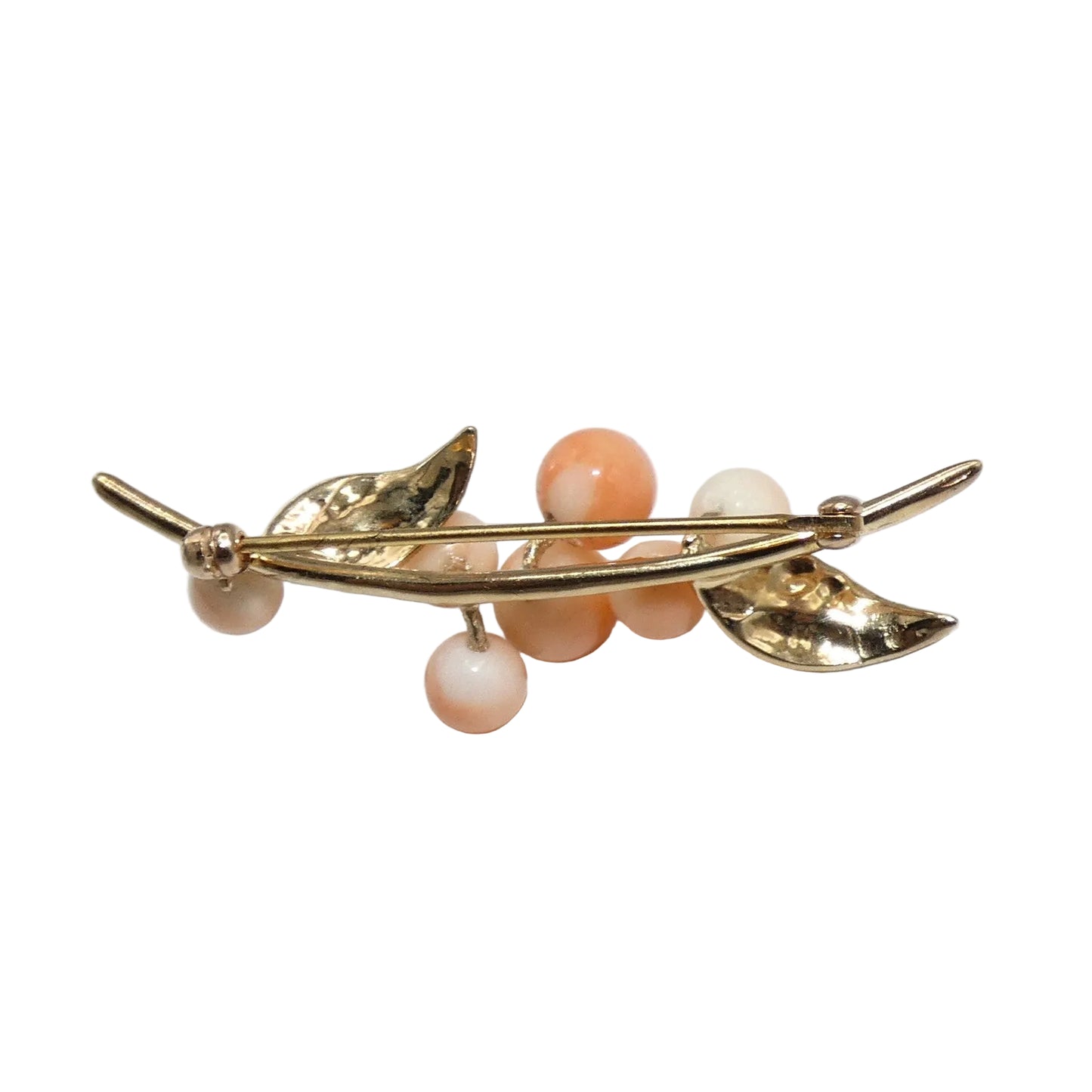 A gold-toned leaf and berry brooch featuring peach and cream colored corals.