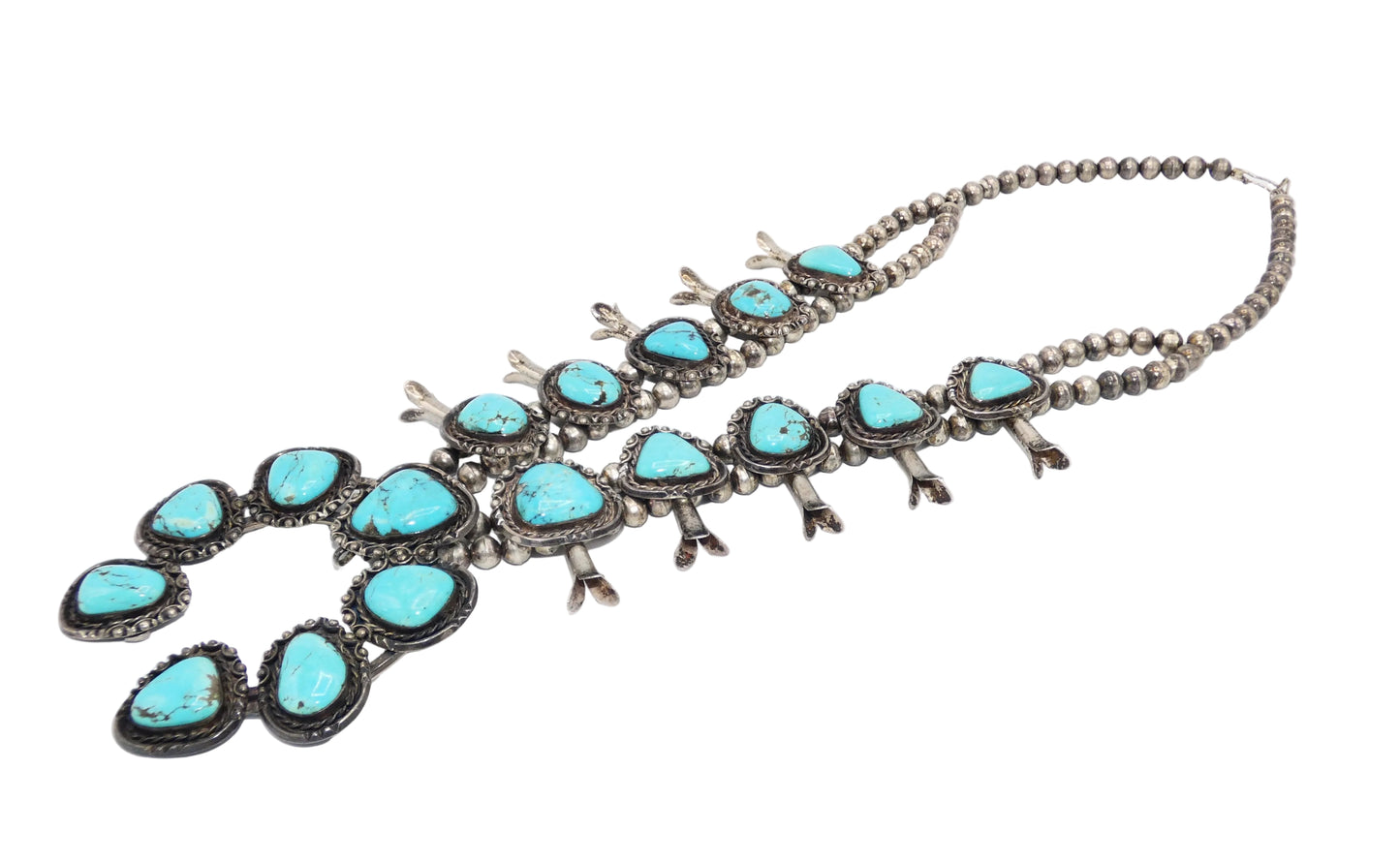 A Southwestern-style turquoise and silver necklace featuring oval and teardrop-shaped turquoise stones set in oxidized sterling silver