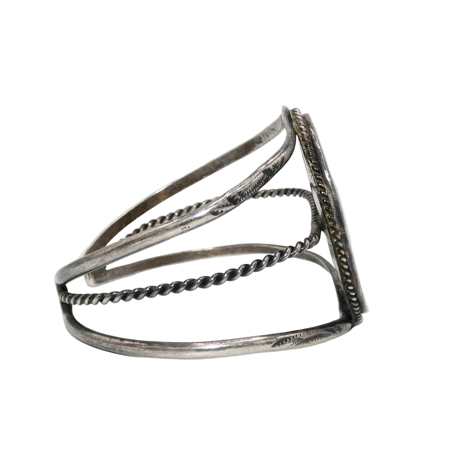 A silver-toned open cuff bracelet with textured twisted wire bands and a flat rectangular end featuring engraved detailing