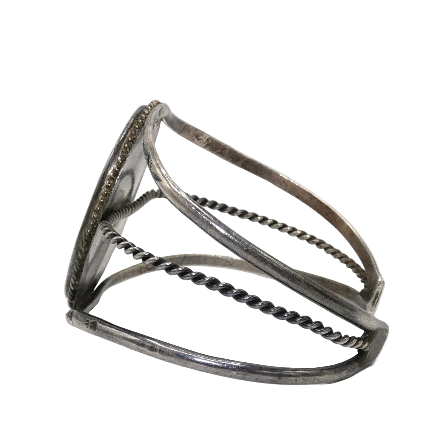 A silver open cuff bracelet with textured twisted wire bands and a flat rectangular end featuring engraved detailing