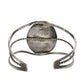 A silver-toned open cuff bracelet with textured twisted wire bands and a flat rectangular end featuring engraved detailing
