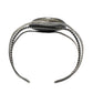 A silver-toned open cuff bracelet with textured twisted wire bands and a flat rectangular end featuring engraved detailing