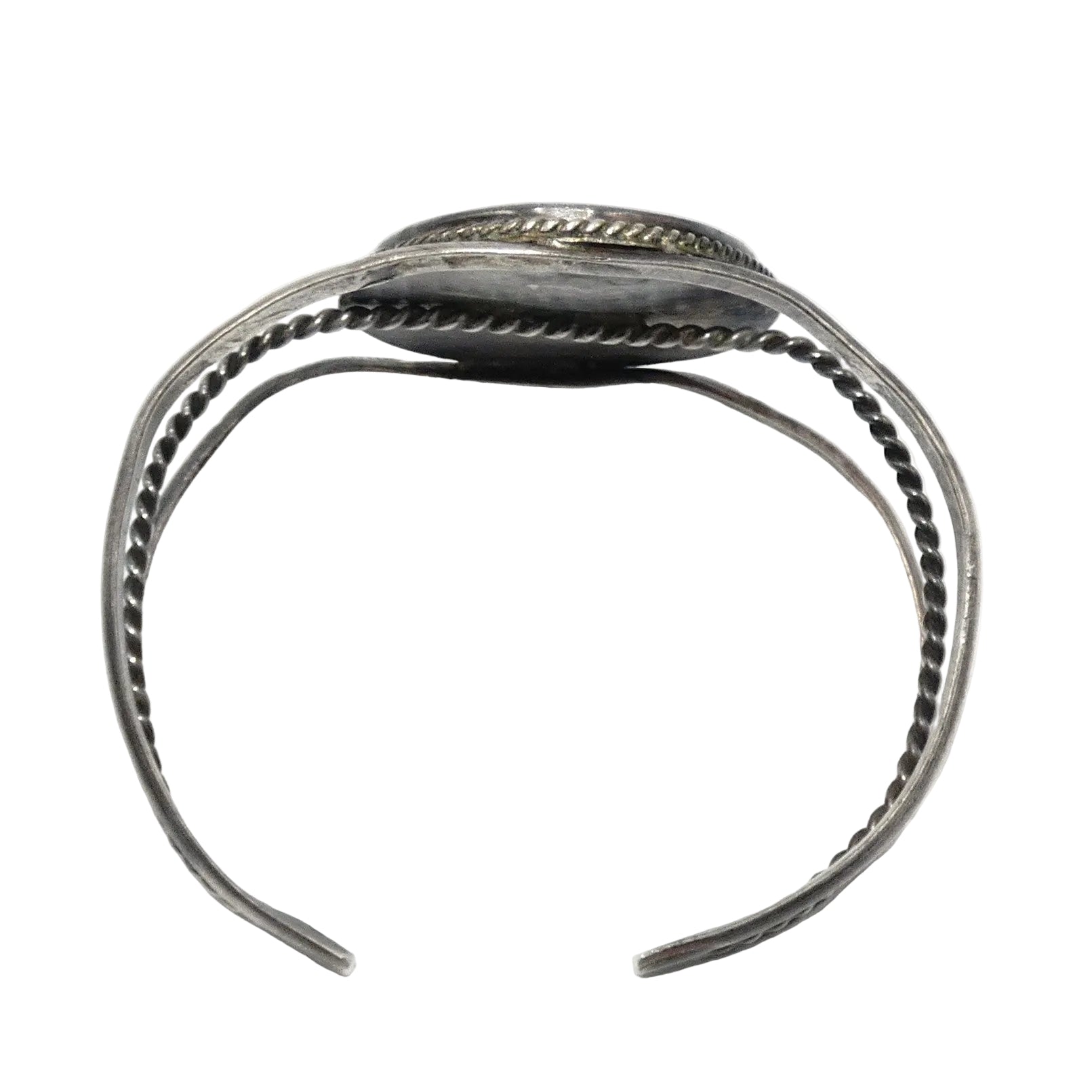 A silver-toned open cuff bracelet with textured twisted wire bands and a flat rectangular end featuring engraved detailing