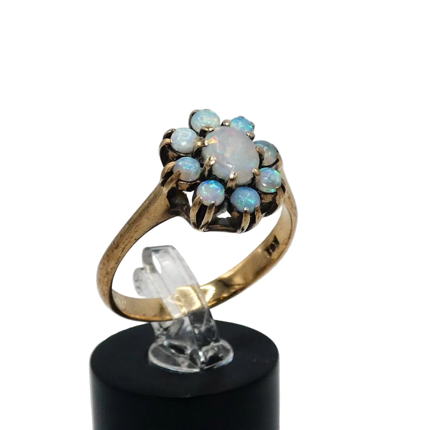 A gold ring featuring a cluster of light blue and white opal gemstones taking the shape of a flower