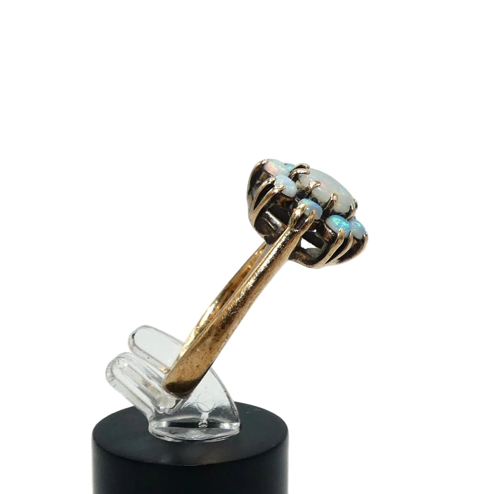 A gold ring featuring a cluster of light blue and white opal gemstones taking the shape of a flower