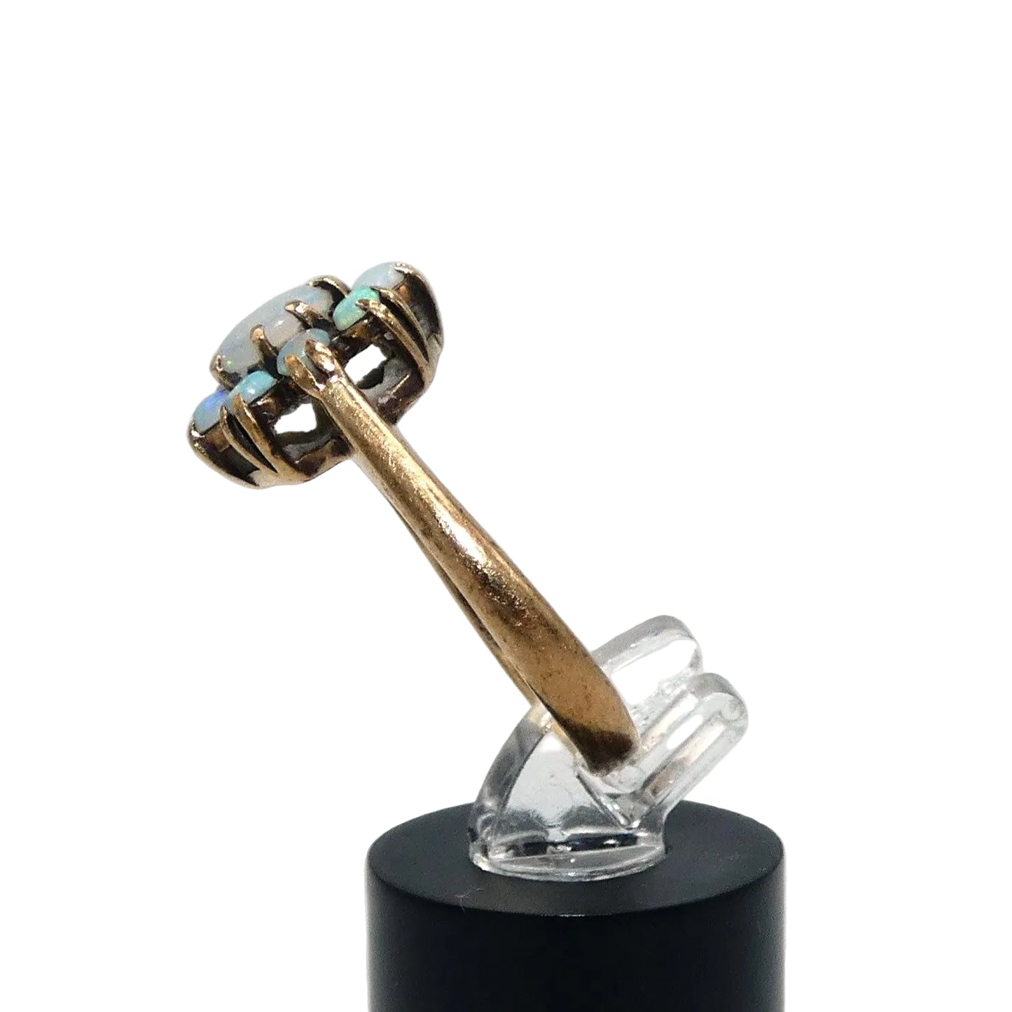 A gold ring featuring a cluster of light blue and white opal gemstones taking the shape of a flower