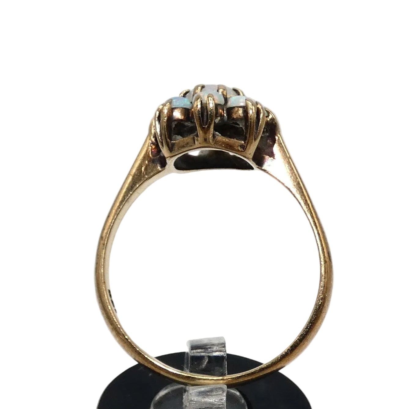 A gold ring featuring a cluster of light blue and white opal gemstones taking the shape of a flower