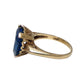 A heart-shaped blue topaz ring set in a 10K gold band with decorative filigree side details in the shape of a heart on both sides
