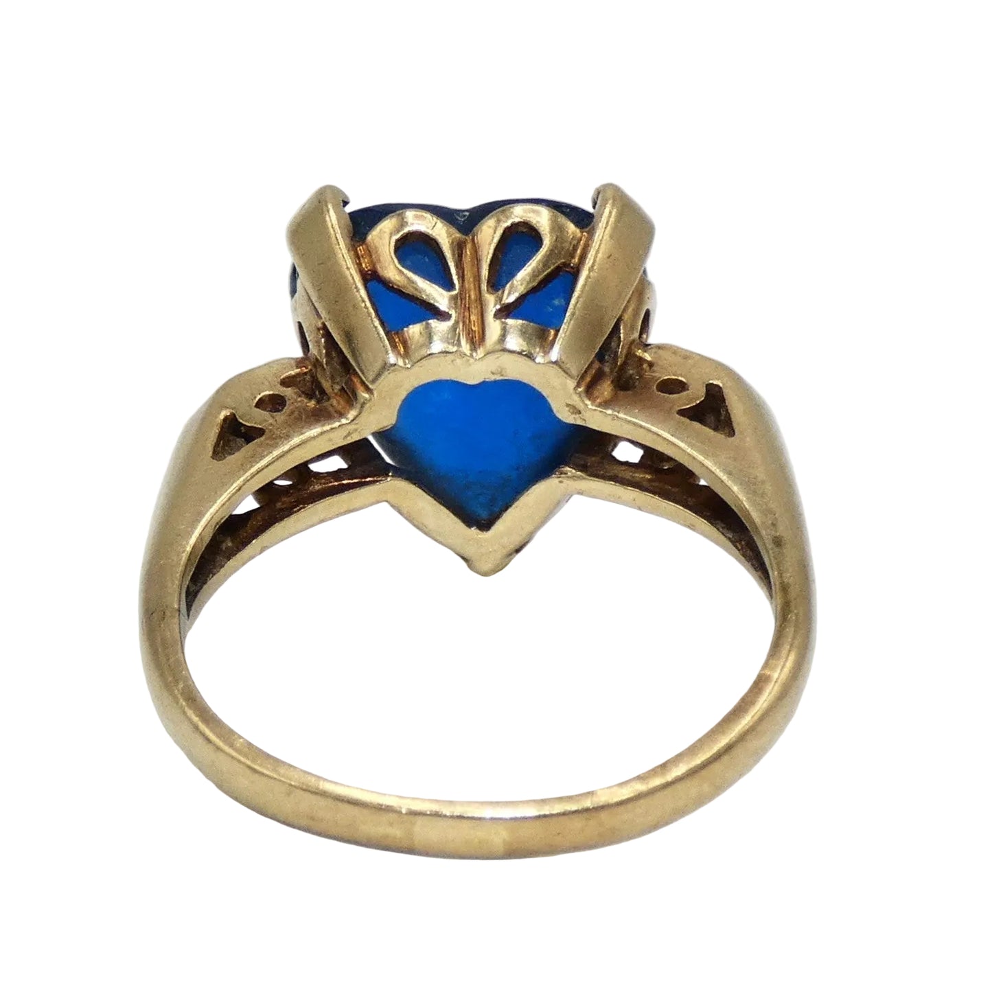 A heart-shaped blue topaz ring set in a 10K gold band with decorative filigree side details in the shape of a heart on both sides