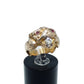 A gold ring shaped like a animal head or creature face, featuring small ruby eyes and a diamond in its mouth