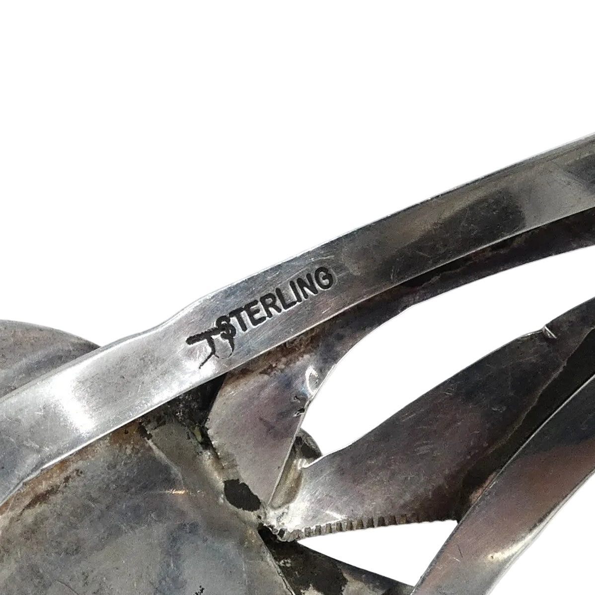 Close-up of a sterling silver cuff bracelet showing the engraved 'STERLING' mark 